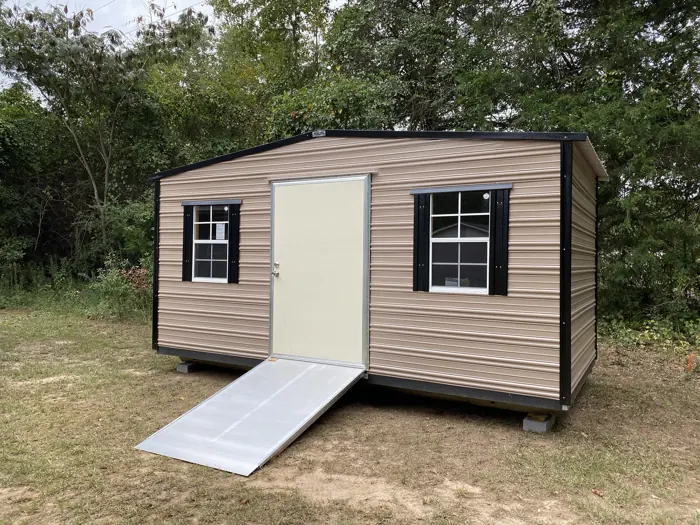 Tan aluminum shed with black trim and shutters and an aluminum ramp