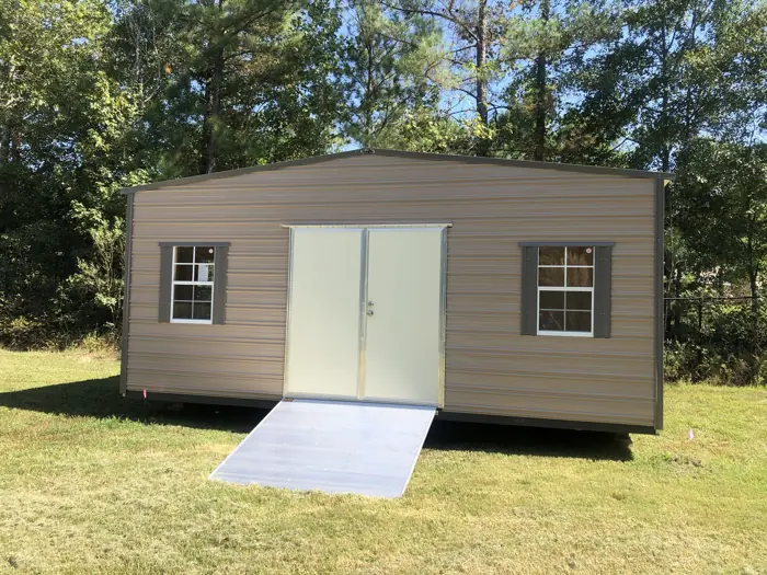 Tan aluminum shed with double doors, dark shutters and a wide aluminum ramp