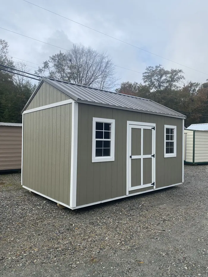 Olive green wood shed with white trim and an upgraded metal roof
